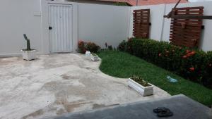 a patio with a yard with flowers and a door at Suítes flor de Mandacaru in Piranhas