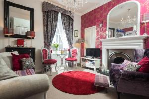 愛丁堡的住宿－邦妮拜德艾瓦公寓，客厅设有粉红色的墙壁和红色的地毯。