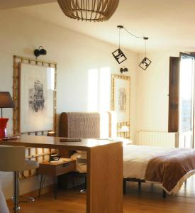 a bedroom with a bed and a desk and windows at Luz del Huécar in Cuenca