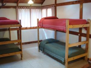 a room with three bunk beds and a window at Búngalows Osa Mayor in Villa La Angostura