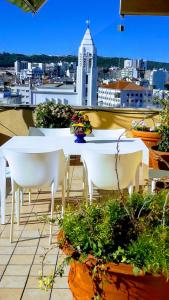 a table and chairs on a balcony with a view of a city at Sunrise Terrace Apartment in Lisbon