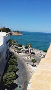 een uitzicht op een straat en de oceaan vanuit een gebouw bij Lofts Miriam in Cádiz