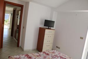 a bedroom with a bed and a tv on a dresser at Le Case dei Pescatori - Coccinella Rossa in Ponza