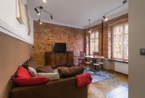 a living room with a couch and a brick wall at Elzbieta Locum / Wroclaw Market Sqr in Wrocław