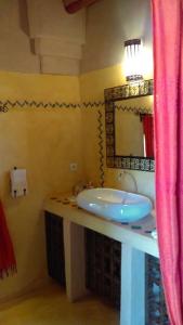 uma casa de banho com um lavatório e um espelho em Dar Lorkam em Skoura