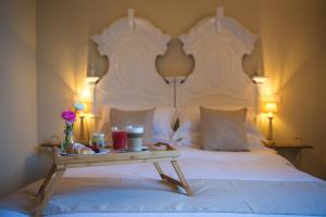 a bed with a table with a tray of food on it at Palazzo Belsanti in Lecce