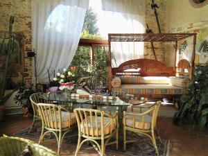 a dining room with a table and chairs and a bed at Locanda La Corte Dei Galli in Carre