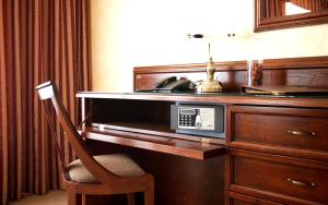 a room with a desk with a microwave and a chair at CityClub Hotel in Tiraspol