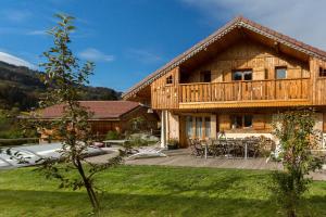 una casa di tronchi con terrazza e patio di Chalet La Grande Ourse a Saint-Gervais-les-Bains