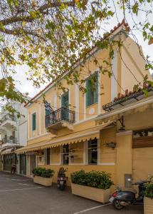 a yellow building with two balconies on a street at Artdecoathens in Athens