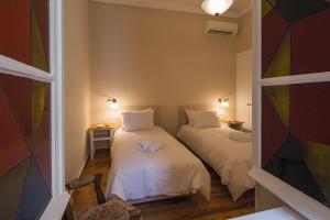 two beds in a small room with a window at Artdecoathens in Athens