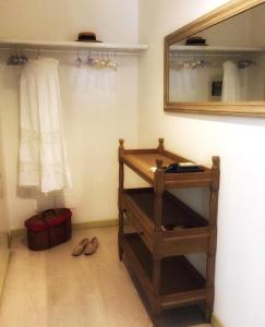 een badkamer met een spiegel, een plank en schoenen bij Appartamento Romantico in Cremona