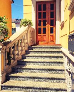 een trap naar een houten deur bij Appartamento Romantico in Cremona