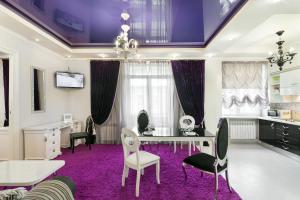 2 bedrooms Apartments Levia 2 في إلفيف: غرفة طعام مع سجادة أرجوانية وطاولة وكراسي
