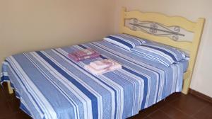 a blue and white striped bed with towels on it at Ap Acolhedor in Fortaleza