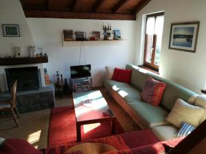 un soggiorno con divano e tavolo di Casa Olivo a Montagnola