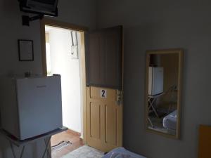 a room with a door and a mirror and a refrigerator at Hotel Nobre in Tupã