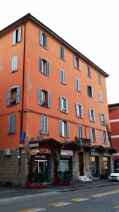 ein großes orangefarbenes Gebäude am Straßenrand in der Unterkunft La Finestra su San Luca in Bologna