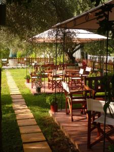 un grupo de mesas y sillas en una terraza de madera en Hotel Avra, en Ligia