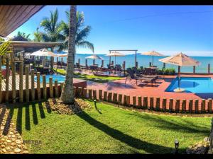 a resort with a pool and tables and umbrellas at Flat Pietra in Florianópolis