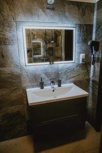 a bathroom with a sink and a mirror at Apartamenty Złota Sowa in Szklarska Poręba +10 photos