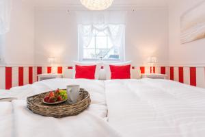 a white bed with a bowl of fruit on it at Villa Strandblick 9 in Zingst