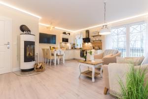 uma sala de estar com uma cozinha e uma sala de estar com uma lareira em Villa Strandblick 9 em Zingst