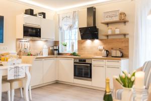 a kitchen with white cabinets and a table at Villa Strandblick 9 in Zingst