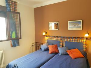 a bedroom with a bed with blue sheets and orange pillows at Villa SABENA in Cazorla +71 photos