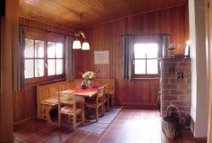 a dining room with a table and chairs and windows at Ellernhof im Spessart in Stadtprozelten