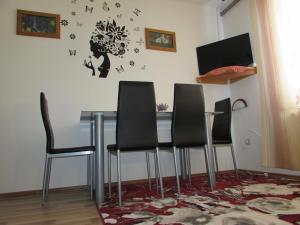 a dining room table with four chairs and a clock on the wall at Apartment Špehar in Seliste Dreznicko