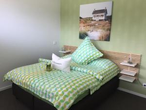 um quarto com uma cama com almofadas em das Ferienhaus Auszeit em Kranenburg