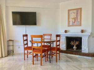 a dining room with a table and chairs and a fireplace at Puerto Marina in Benalmádena