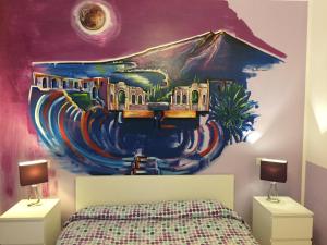 a bedroom with a painting on the wall at B&B La Terrazza Sul Mare Taormina in Taormina