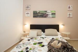 1 dormitorio con 1 cama con colcha de flores en B&B Trio D'Archi - La Pilozza Infiorata, en Caltagirone