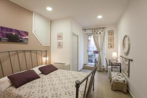 a bedroom with a bed and a window at B&B Trio D'Archi - La Pilozza Infiorata in Caltagirone
