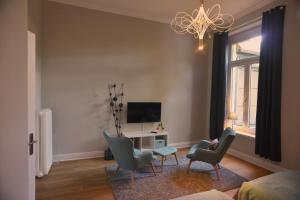 a living room with chairs and a table and a television at City-Apartment Reger Privatparkplatz in Krefeld