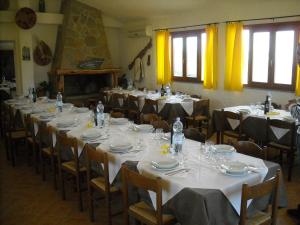 a room filled with tables and chairs with white tablecloths at Agriturismo Depalmas in Stintino +37 photos