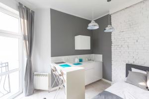 a white bathroom with a sink and a white brick wall at Apartament w centrum Poznania Old Town in Poznań