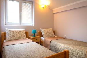 - une chambre avec 2 lits et une fenêtre dans l'établissement Athos Apartments, à Niš