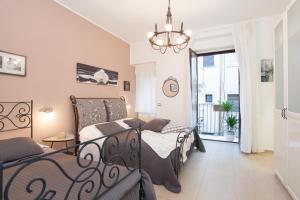 a bedroom with two beds and a chandelier at B&B Trio D'Archi - La Pilozza Infiorata in Caltagirone