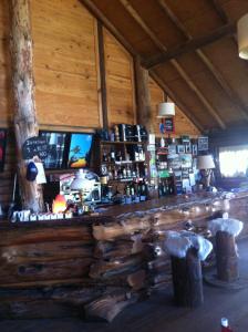 a bar in a cabin with a wooden counter at Hostería de Montaña los Duendes del Volcán in Caviahue