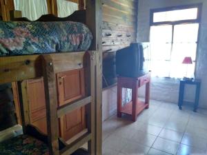 a bedroom with a bunk bed and a table with a tv at Albergue Gaia in El Bolsón