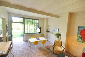 een woonkamer met een tafel en gele stoelen bij La maison du fond du jardin in Brussel