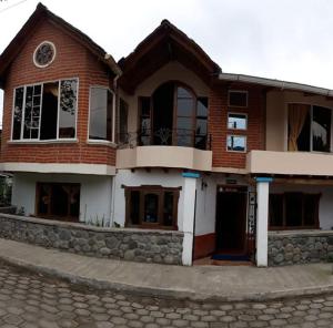 a large brick house on a cobblestone street at Casa Cultural Mindo in Mindo