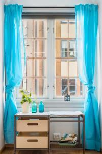 una ventana con cortinas azules y una mesa delante de ella en SG Apartments, en Bergen