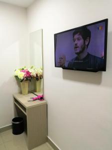 a flat screen tv hanging on a wall with flowers at CITI HOTEL @ KL SENTRAL in Kuala Lumpur