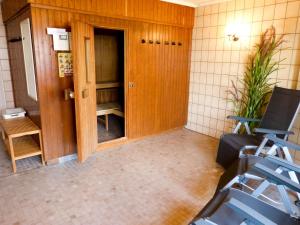 Zimmer mit Tür und zwei blauen Stühlen in der Unterkunft Haus Therese *FeWo 14* in Wittdün