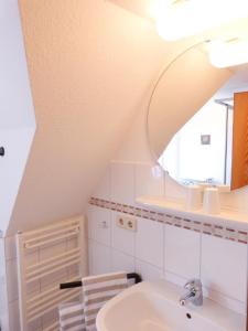 een badkamer met een wastafel en een spiegel bij Ferienwohnung Bi Elschen in Nebel