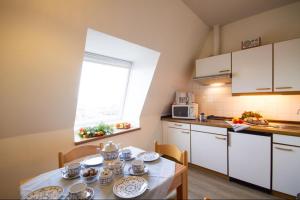 una cucina con tavolo e stoviglie di Haus Therese Ferienwohnung *Feodora* (App.11) a Wittdün